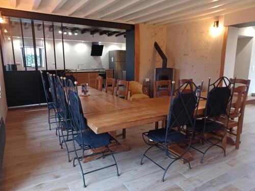 a large wooden table and chairs in a room at Au Gîte Savignéen in Savigné-lʼÉvêque