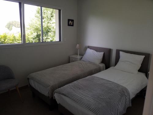 Dos camas individuales en una habitación con ventana. en Armor, en Bonne Nouvelle