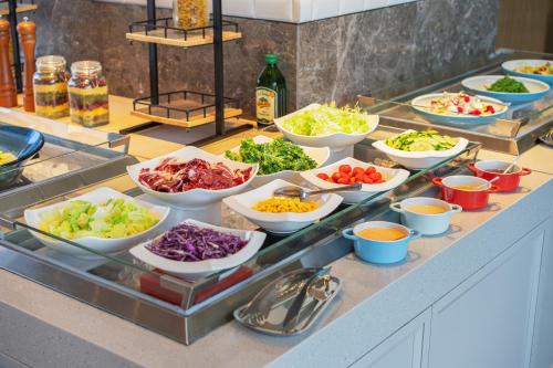 um buffet com muitas tigelas de diferentes tipos de comida em Holiday Inn Zhuhai City Center by IHG em Zhuhai