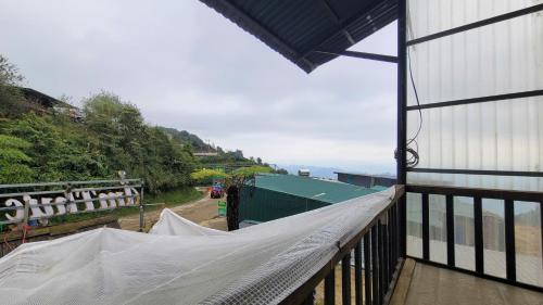 un balcon avec un hamac sur le côté d'un bâtiment dans l'établissement Chà Homestay, à Bắc Yên