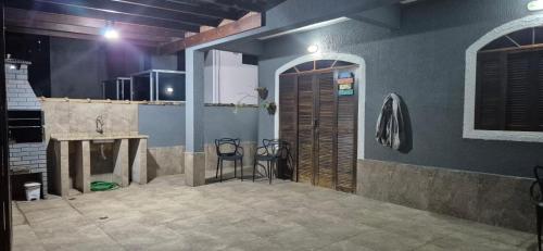 Zimmer mit einer Küche und einer Holztür in der Unterkunft Casa Pouso Aconchego Para Ti - pertinho de Trindade com conforto e churrasqueira in Paraty