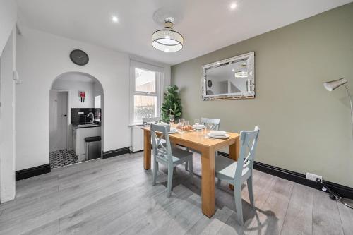 a dining room with a wooden table and chairs at Modern Bletchley home with stylish decor in Bletchley