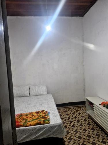 a room with a bed and a light on the wall at Pousada Rio do Mar in Aracaju