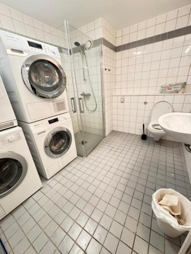 une salle de bains avec lave-linge et lavabo dans l'établissement Guesthouse good location, à Oslo
