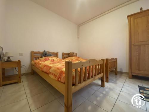 a bedroom with a wooden bed in a room at Grenache rdc in Fosse