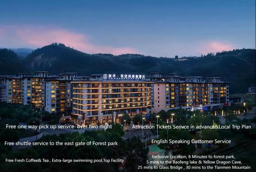 a large building with lights on in front of a mountain at Zhangjiajie SANHE Hotel in Zhangjiajie