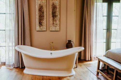 eine Badewanne in einem Zimmer mit Fenstern in der Unterkunft Vabali Spa Hamburg Hotel in Glinde