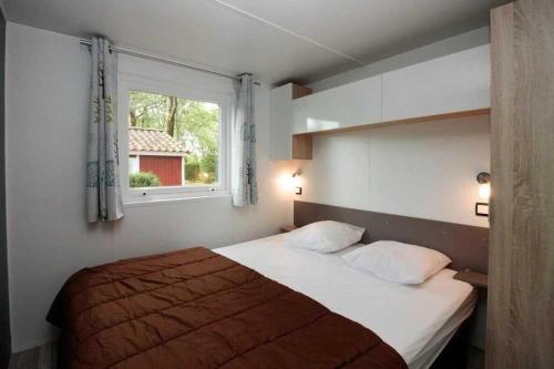 ein Schlafzimmer mit einem Bett und einem Fenster in der Unterkunft Chalet 4 étoiles - Piscine - ccafdif in Loupiac