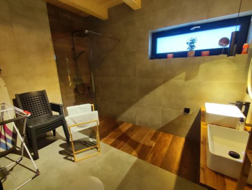a bathroom with a tv on the wall and a chair at Villa Panorama in Żywiec