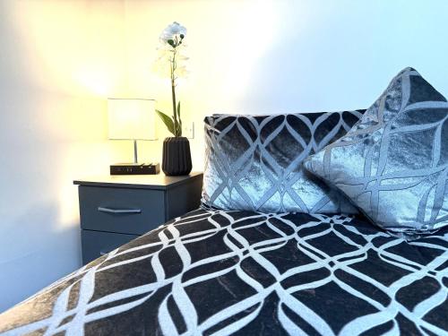 a bedroom with a bed and a table with a lamp at Maggie's Lodge in Leeds