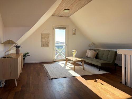 a living room with a couch and a table at Gult Strandhus Med Udsigt Over Løkken in Løkken