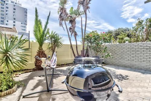 布鲁堡史特兰Modern Duplex Fully Air-Conditioned near Beach的一艘小船停泊在棕榈树环绕的庭院里。