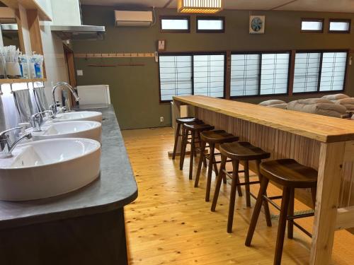 une grande salle de bains avec trois lavabos et un bar avec tabourets dans l'établissement SABOJI - Vacation STAY 34265v, à Takamori