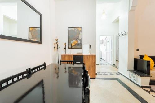 ein Wohnzimmer mit weißen Wänden und einem TV in der Unterkunft Charming Flat with AC Fast Wifi Secure Residence in Oulad Akkou