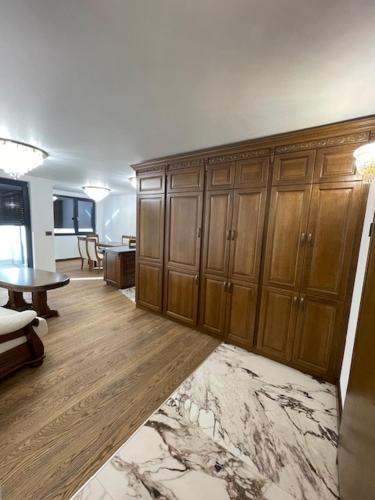 Zimmer mit Holzschränken und einem Tisch in einem Zimmer in der Unterkunft Luxury Apartment Downtown Blagoevgrad in Blagoewgrad