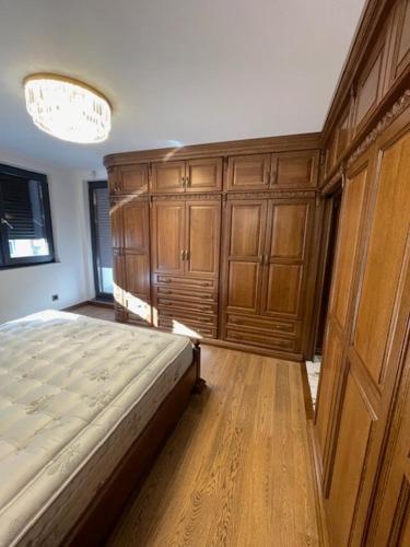 ein Schlafzimmer mit einem großen Bett und Holzschränken in der Unterkunft Luxury Apartment Downtown Blagoevgrad in Blagoewgrad