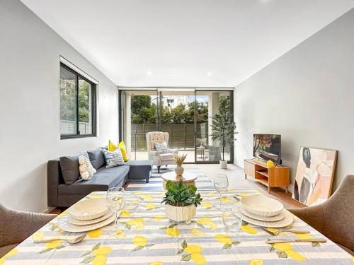 a living room with a table and a couch at Chatswood Gem Steps to Metro, Mall & Park in Sydney