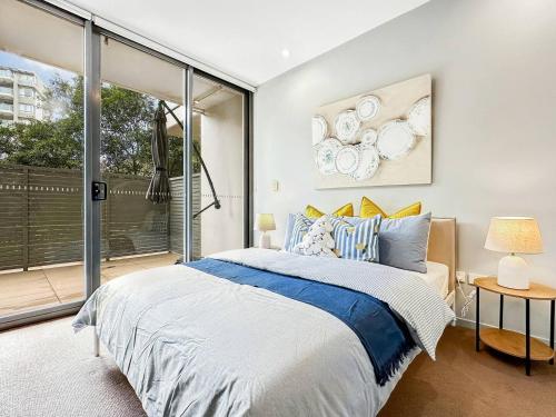 a bedroom with a bed and a large window at Chatswood Gem Steps to Metro, Mall & Park in Sydney