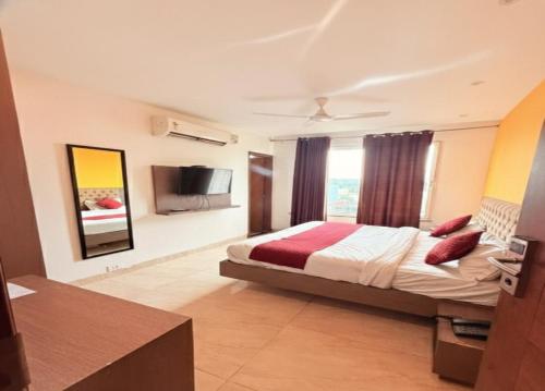 a hotel room with a bed and a television at Hotel Melano Ambala Chandigarh Rd Zirakpur SkyJumper park in Zirakpur