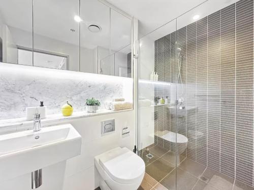 a bathroom with a toilet and a sink and a shower at Chatswood Gem Steps to Metro, Mall & Park in Sydney