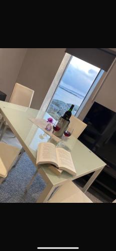 a glass table with a bottle of wine and a book at Atlantic beach house in Dog Island