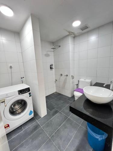 un bagno con lavatrice e lavandino di Chambers Skylight Suites Klcc a Kuala Lumpur