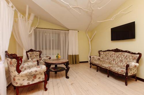 a living room with two chairs and a table at Ecopark VII NEBO in Kirovskoye