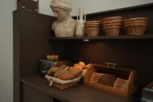 een plank met een beeld en een fruitmand bij Hotel Frohnhauser Hof in Essen