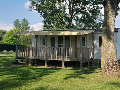 a small house with a porch and a tree at ZEcamping 4 étoiles dog friendly bar piscine couverte in Faverolles-sur-Cher