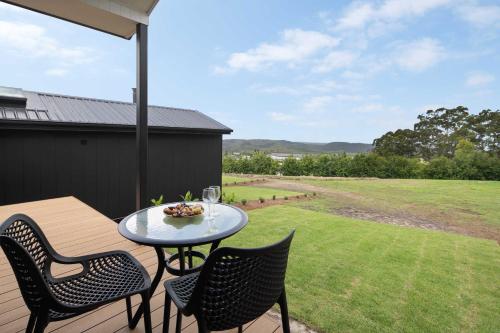 a patio with a table and chairs on a deck at Lemon Myrtle Villa in Valdora