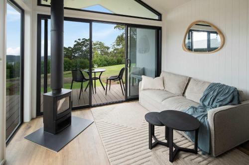 a living room with a couch and a wood stove at Lemon Myrtle Villa in Valdora