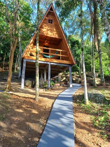 a cabin in the woods with a walkway at Chalé com jacuzzi Florianópolis in Florianópolis