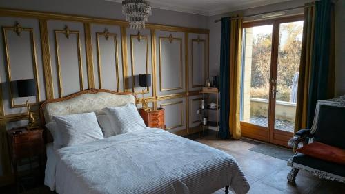 une chambre avec un lit et une grande fenêtre dans l'établissement BonBon Chambre d'hôtes, à Saint-Julien-de-Lampon