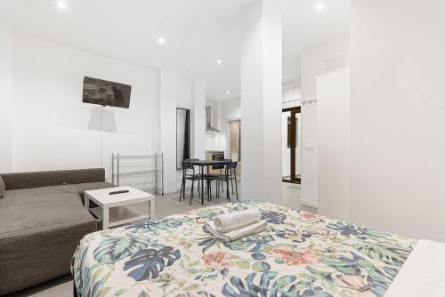 a living room with a bed and a couch at Apartamentos Calle Nueva in Málaga