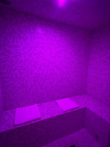 a purple room with pink lights on the wall at Artemide Resort Spa - Private Villa & Spa Suites in Lido Di Fondi