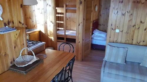 a room with two bunk beds and a table in a cabin at ZEcamping 2 étoiles animaux acceptés snack-bar et vue lac in Neffes