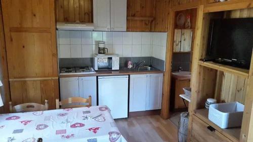 a kitchen with white cabinets and a table in a room at ZEcamping 2 étoiles animaux acceptés snack-bar et vue lac in Neffes