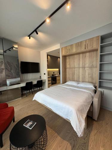 a bedroom with a large bed and a living room at BW Lux Apartments in Sajmište