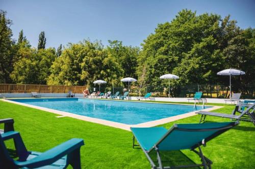 - une piscine avec des chaises longues et des parasols dans l'établissement Camping 3 étoiles - Piscine - eeicbi, à Le Change
