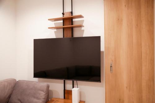 uma TV de tela plana pendurada na parede em 福岡旅路 博多住吉包棟民宿 3號館 em Fukuoka