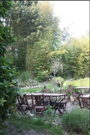 a picnic table and benches in a garden at Grange de Pierrot in Braine-lʼAlleud