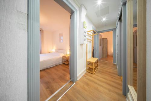 um pequeno quarto com uma cama e um corredor em appartement confortable à la frontière de bâle One 6 personnes em Saint-Louis