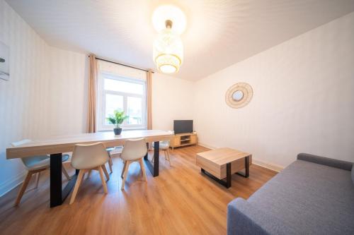 uma sala de estar com uma mesa de jantar e um sofá em appartement confortable à la frontière de bâle One 6 personnes em Saint-Louis