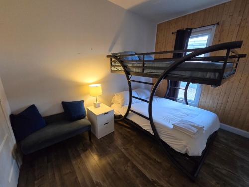 a bedroom with a bunk bed and a couch at Chez Temporel - Condo urbain in Quebec City