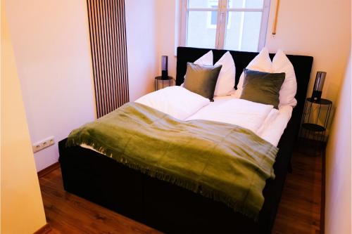 ein Schlafzimmer mit einem Bett mit weißen Laken und Kissen in der Unterkunft Modern Apartment near Therme Erding WIFI in Erding