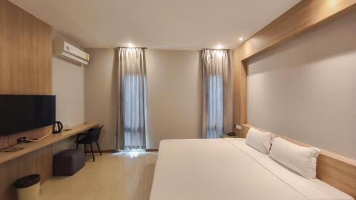 a hotel room with a bed and a flat screen tv at C Hotel Bangna in Bangkok