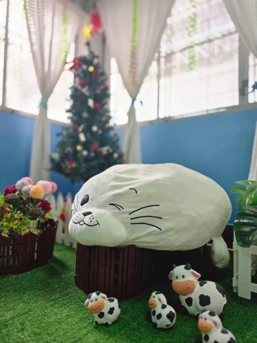 a cake of a cat with three cows in front of a christmas tree at Apartment near Central Festival Hatyai in Hat Yai