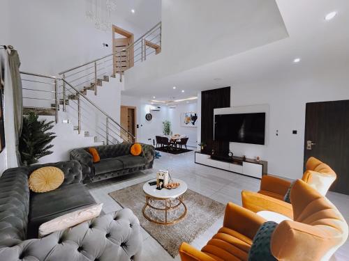 a living room with black leather couches and a tv at Sahara Apartment Ikoyi in Lagos