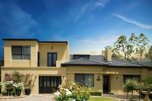 a large yellow house with a roof at Chateau Yaldara House in Lyndoch