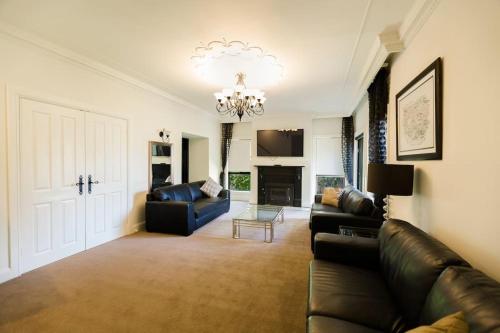 a living room with a couch and a chandelier at Chateau Yaldara House in Lyndoch